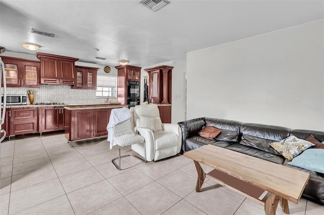 living area featuring light tile patterned floors and visible vents