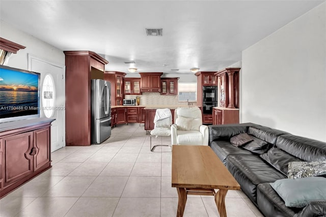 living room featuring light tile patterned floors and visible vents