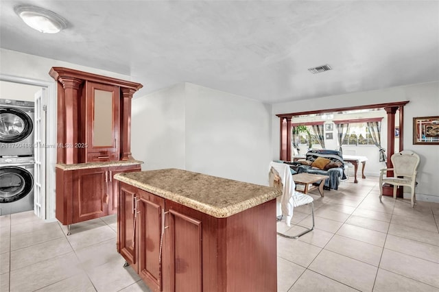 kitchen featuring light countertops, stacked washing maching and dryer, and a kitchen island