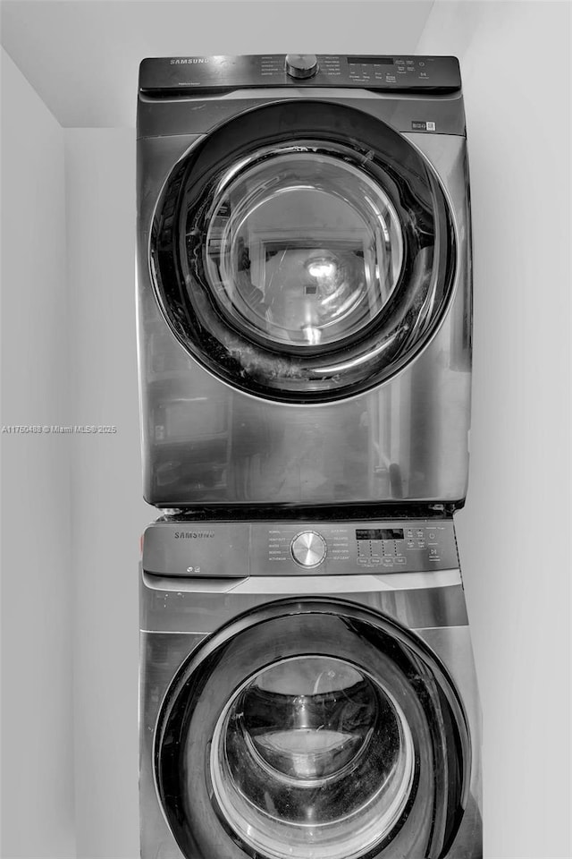 washroom featuring stacked washer and clothes dryer and laundry area