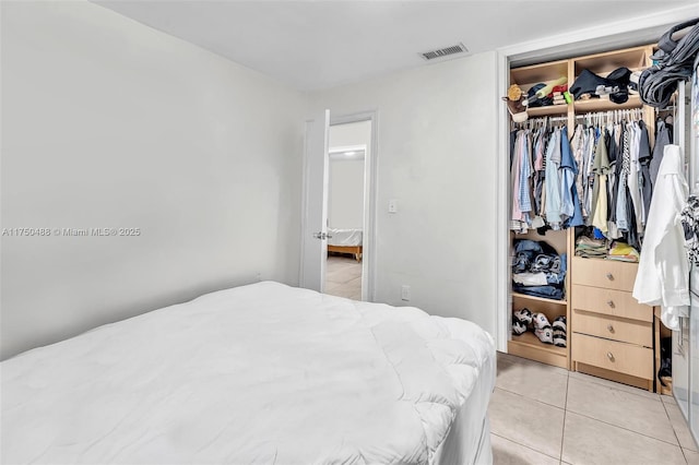 bedroom featuring light tile patterned floors, a closet, and visible vents