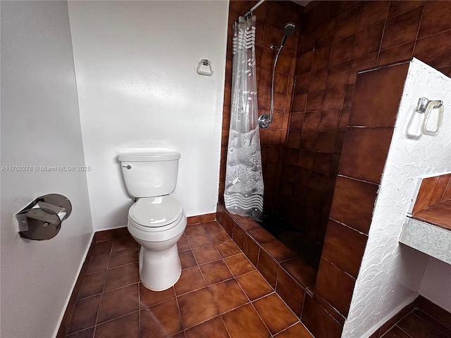 full bathroom with toilet, a shower stall, baseboards, and tile patterned flooring