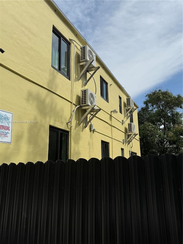 view of property featuring ac unit and fence