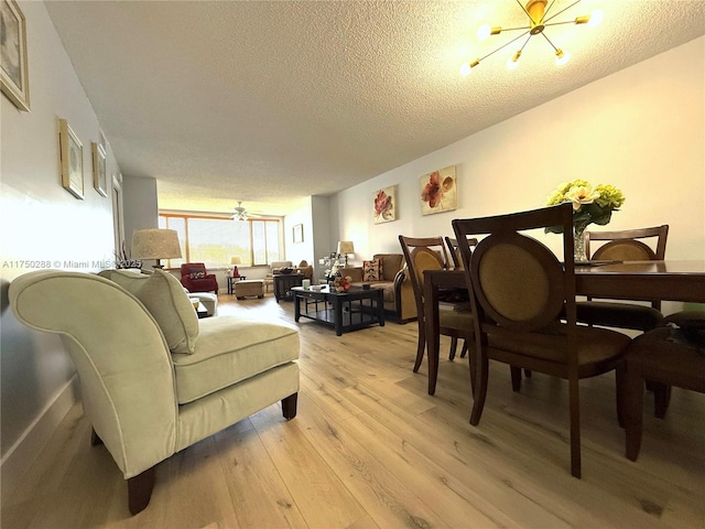 living area featuring a textured ceiling, light wood-type flooring, and a chandelier