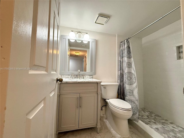 bathroom featuring toilet, a tile shower, and vanity