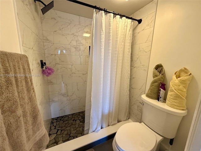 full bathroom featuring a tile shower and toilet