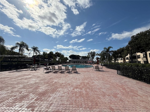 pool with fence and a patio