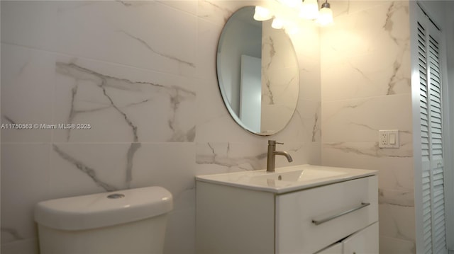 bathroom featuring toilet, a closet, and vanity