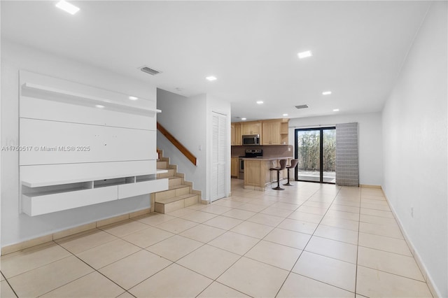 interior space with light tile patterned flooring, recessed lighting, visible vents, baseboards, and stairway