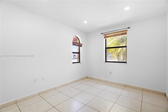 empty room featuring recessed lighting, baseboards, and light tile patterned floors