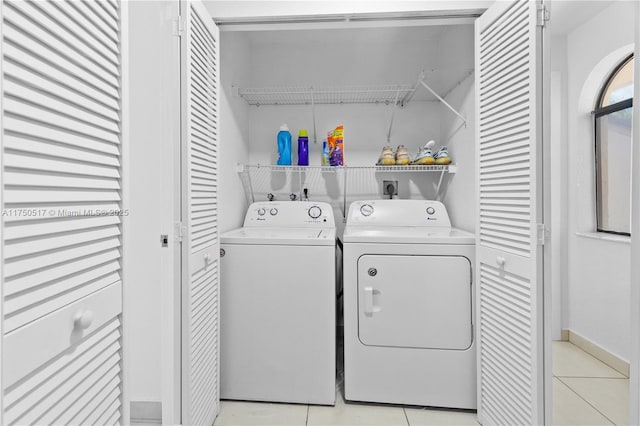 laundry room featuring laundry area, light tile patterned floors, and washer and clothes dryer