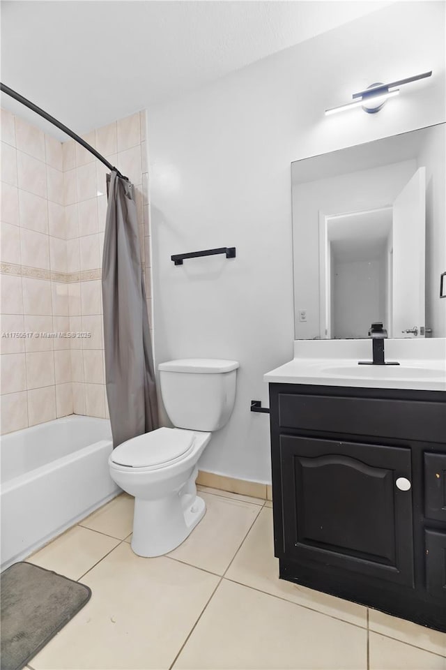 bathroom with baseboards, toilet, tile patterned flooring, shower / bath combo with shower curtain, and vanity