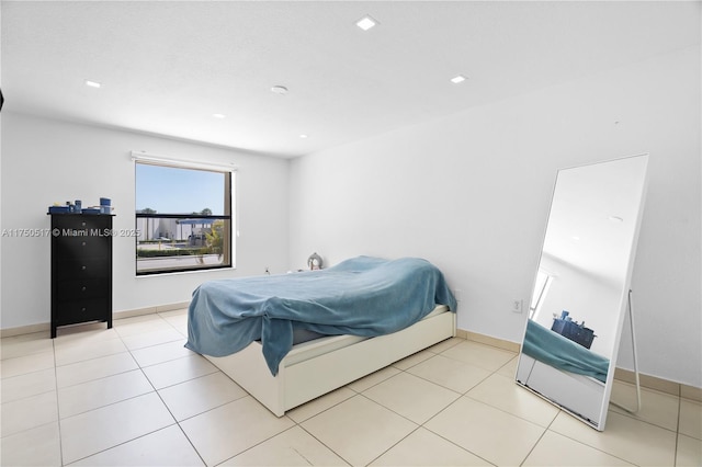 bedroom with light tile patterned floors and baseboards