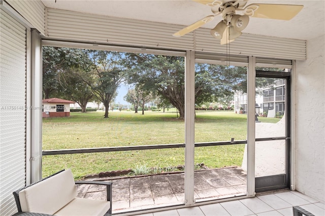 unfurnished sunroom with ceiling fan