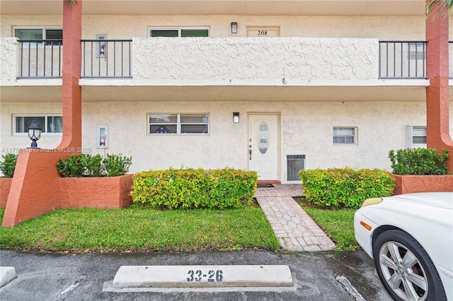 doorway to property featuring a balcony and stucco siding