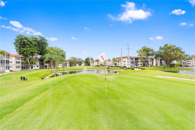 surrounding community with a water view and a yard