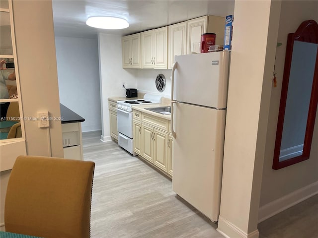 kitchen with white appliances, light wood-type flooring, and baseboards