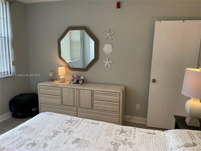 bedroom featuring baseboards and wood finished floors