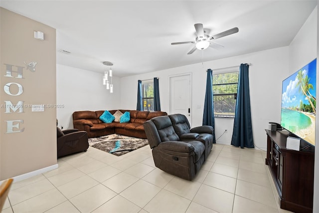 living room featuring light tile patterned floors, visible vents, baseboards, and a ceiling fan