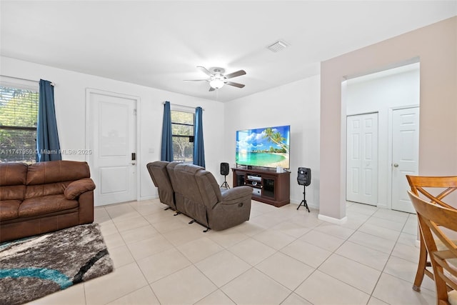 living room with ceiling fan, visible vents, baseboards, and light tile patterned flooring