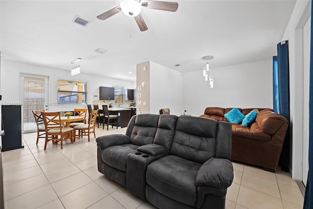 living area with visible vents, ceiling fan, and light tile patterned floors