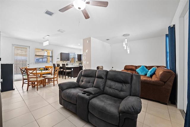 living area with light tile patterned floors, a ceiling fan, and visible vents