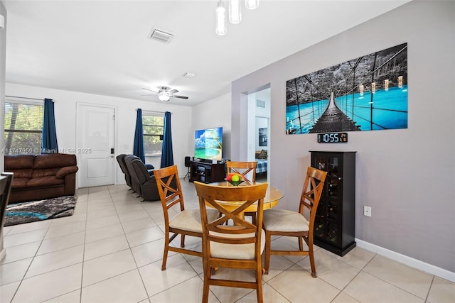 dining area featuring light tile patterned floors, baseboards, ceiling fan, and visible vents