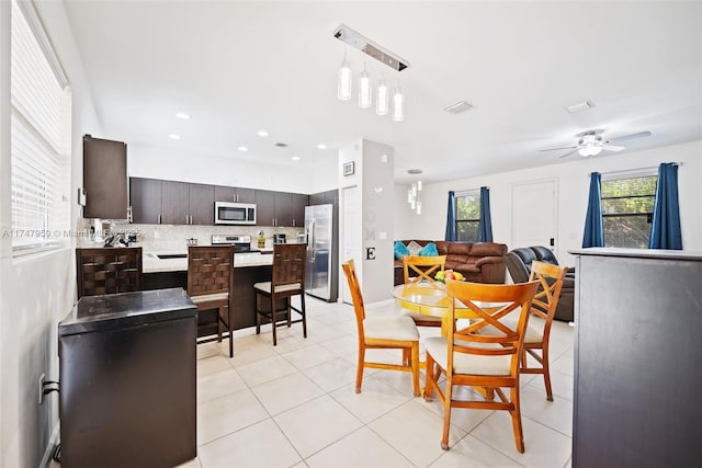 dining room with ceiling fan, visible vents, a healthy amount of sunlight, and light tile patterned flooring