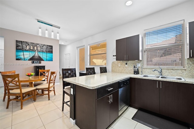 kitchen featuring dishwasher, decorative backsplash, a peninsula, light tile patterned flooring, and a sink