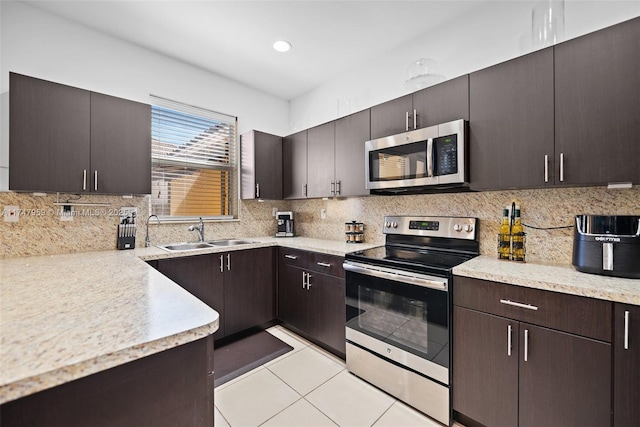 kitchen featuring decorative backsplash, appliances with stainless steel finishes, light countertops, and a sink