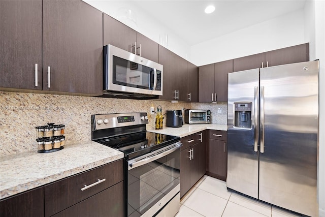 kitchen with decorative backsplash, dark brown cabinetry, light tile patterned floors, and appliances with stainless steel finishes