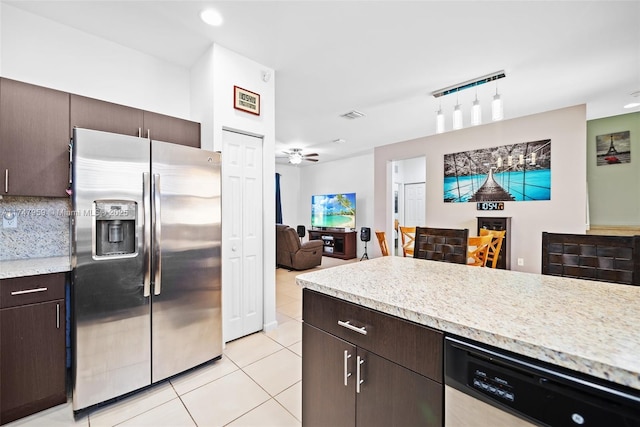 kitchen with light tile patterned flooring, appliances with stainless steel finishes, open floor plan, decorative backsplash, and dark brown cabinets