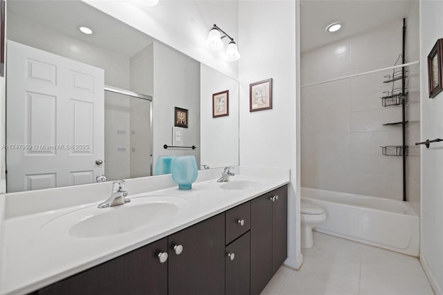 bathroom featuring a sink, toilet, double vanity, and tile patterned floors