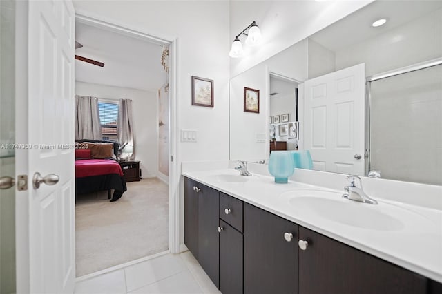 ensuite bathroom featuring double vanity, tile patterned flooring, connected bathroom, and a sink