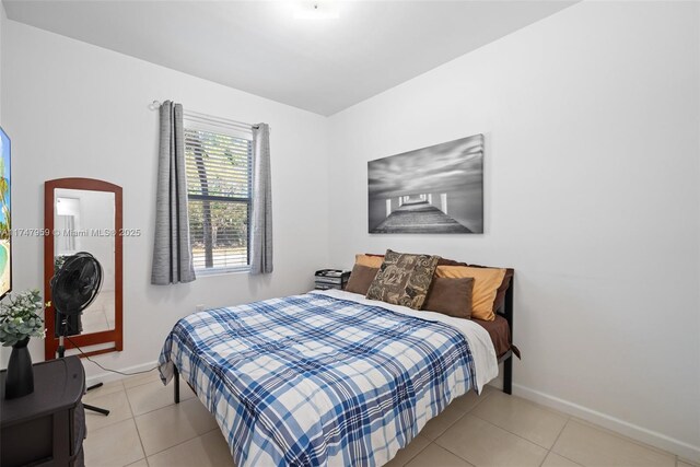bedroom featuring light tile patterned flooring and baseboards