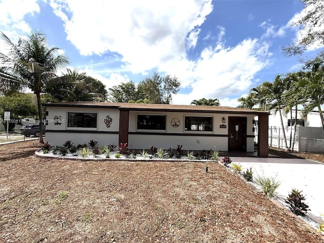 ranch-style house featuring fence and stucco siding