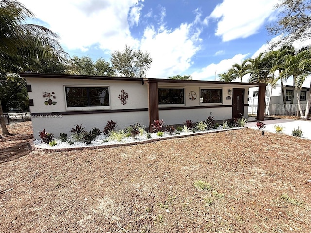 view of front facade featuring fence and stucco siding