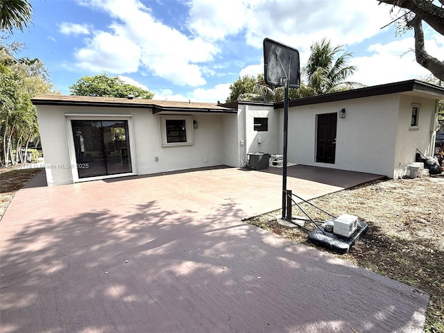 rear view of house featuring a patio area and stucco siding