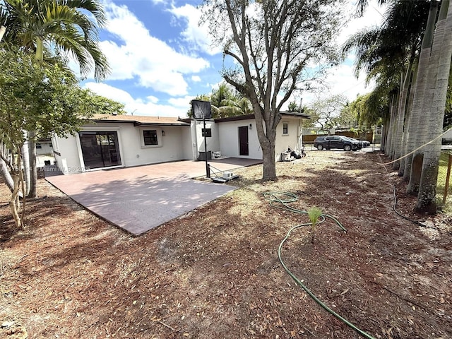 back of property with a patio area and stucco siding