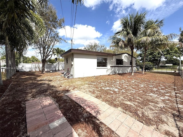 exterior space with a fenced backyard and stucco siding