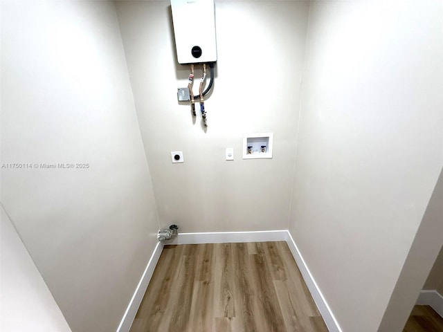 clothes washing area with hookup for a washing machine, hookup for an electric dryer, laundry area, wood finished floors, and baseboards