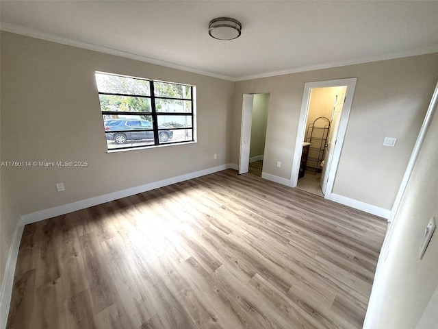 unfurnished bedroom featuring light wood-style flooring, baseboards, ensuite bathroom, and ornamental molding