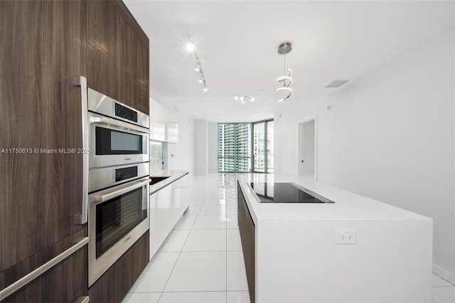 kitchen with decorative light fixtures, light tile patterned floors, light countertops, white cabinetry, and modern cabinets