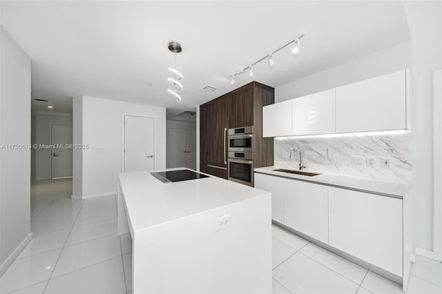 kitchen featuring black electric stovetop, hanging light fixtures, a kitchen island, dark brown cabinetry, and a sink