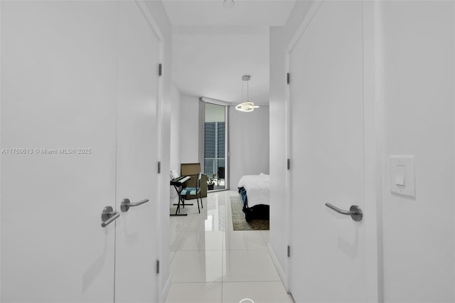 corridor featuring floor to ceiling windows and light tile patterned flooring