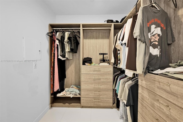 walk in closet with light tile patterned floors