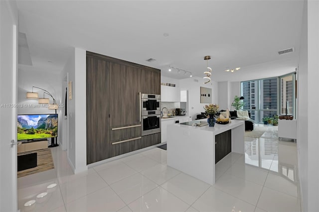 kitchen featuring tasteful backsplash, white cabinets, modern cabinets, a kitchen island, and light countertops