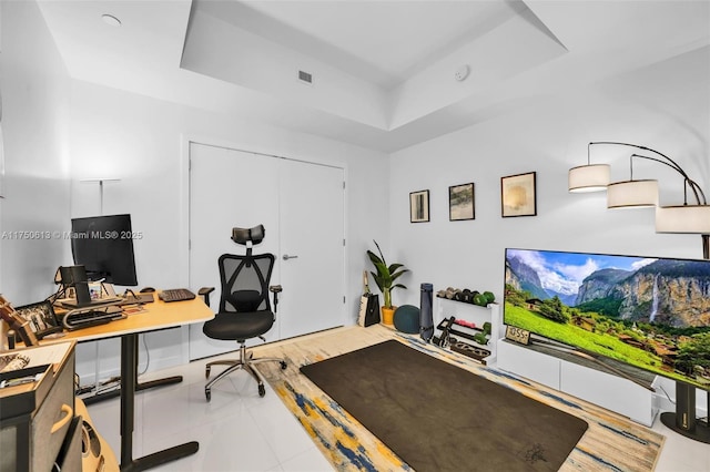 office space featuring light tile patterned floors, a raised ceiling, and visible vents