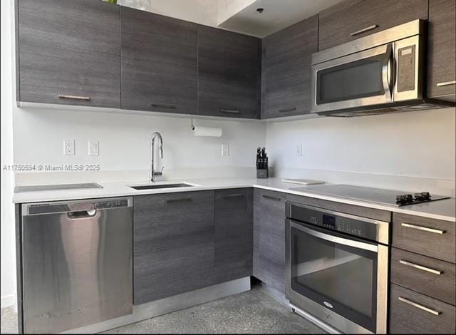 kitchen featuring modern cabinets, appliances with stainless steel finishes, light countertops, and a sink