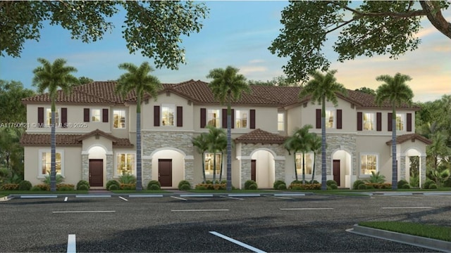 mediterranean / spanish-style house featuring stone siding, a tiled roof, uncovered parking, and stucco siding